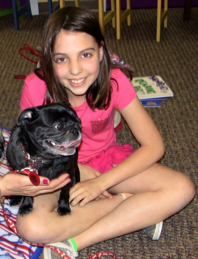 Therapy Pug in reading program with little girl