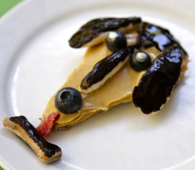 Dog Licks dachshund face cookie with peanut butter, blue berries, strawberry and carob decorations