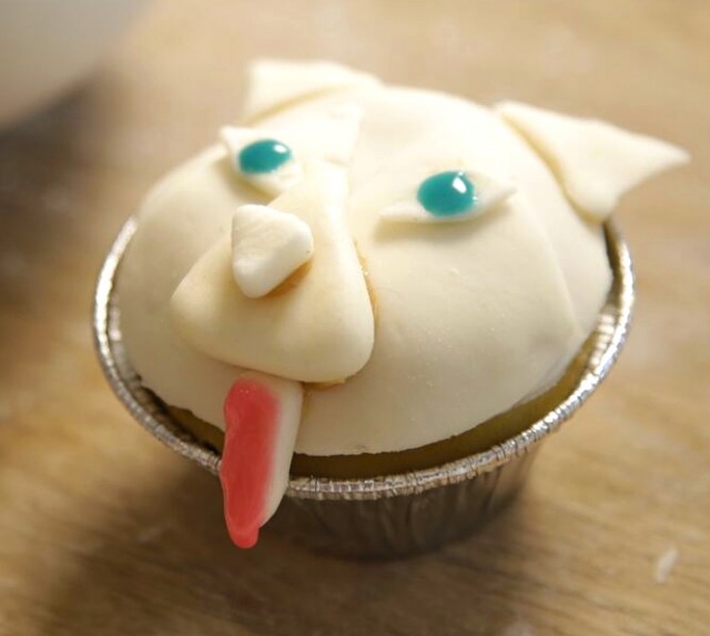 blue eyes and a pink tongue are added to white fondant on husky cupcake for Dog Licks recipe